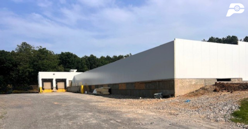Refrigerated warehouse building exterior showing insulated panel walls and dock doors during construction