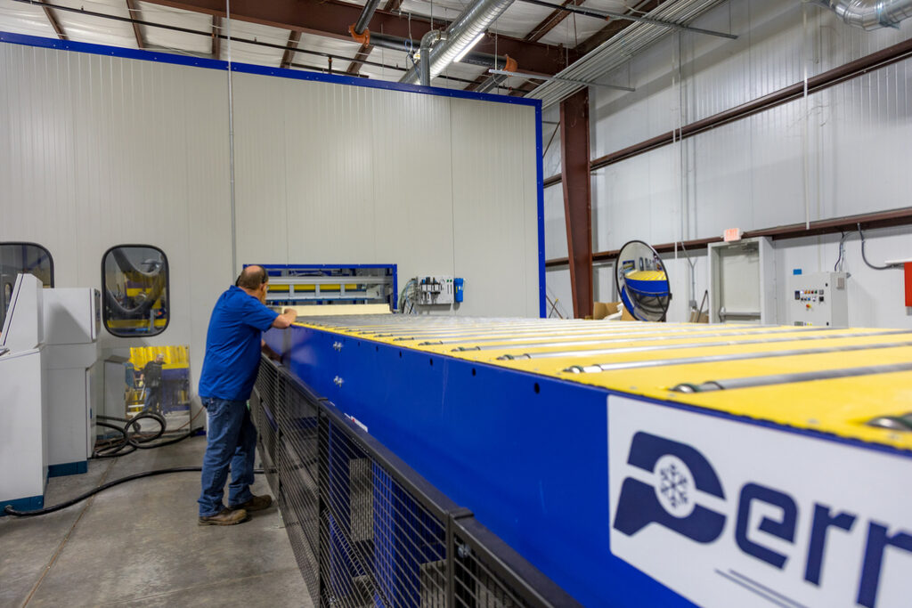 PermaTherm staff checking the insulated panels being produce by the machine.